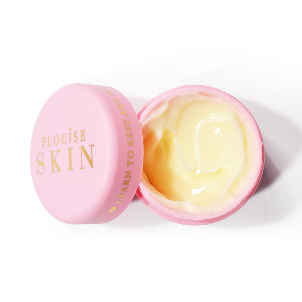 Un borcan deschis de culoare roz de P.Louise Give It A Rest Eye Cream care arată crema hidratantă cu nuanță galbenă din interior