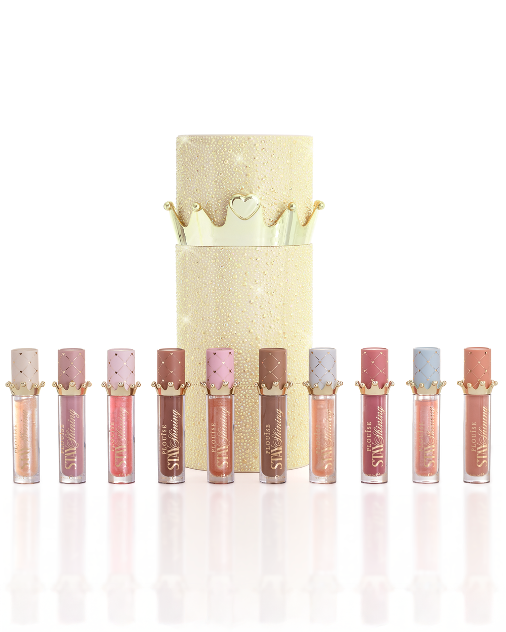 Un set de zece produse de ulei de buze P.Louise Christmas stay strălucitoare dispuse la rând în fața unei cutii de ulei de buze cilindrice auriu strălucitor, cu un capac de coroană aurie, pe un fundal alb curat. Produs lichid pentru buze Lip Oil cu un aplicator de picior de căprioară în timp ce ține tubul în cealaltă mână, așezat pe un fundal alb curat.