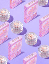 Recipiente transparente de P.Louise DOse of Dreams Viatmin C Capsule Cremă de față cu capsulă roz în ele înconjurate de cutii de cereale roz pe un fundal violet