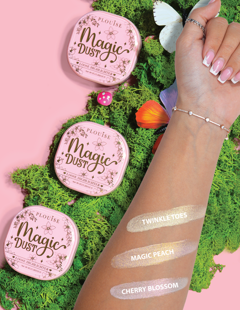 Trei iluminatoare compacte libere etichetate Magic Dust în nuanțe Twinkle Toes, Magic Peach și Cherry Blossom, afișate pe un braț cu un fundal floral.
