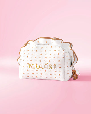 A P.Louise frilled makeup and skincare bag with a small print teddy bear design against a pink background