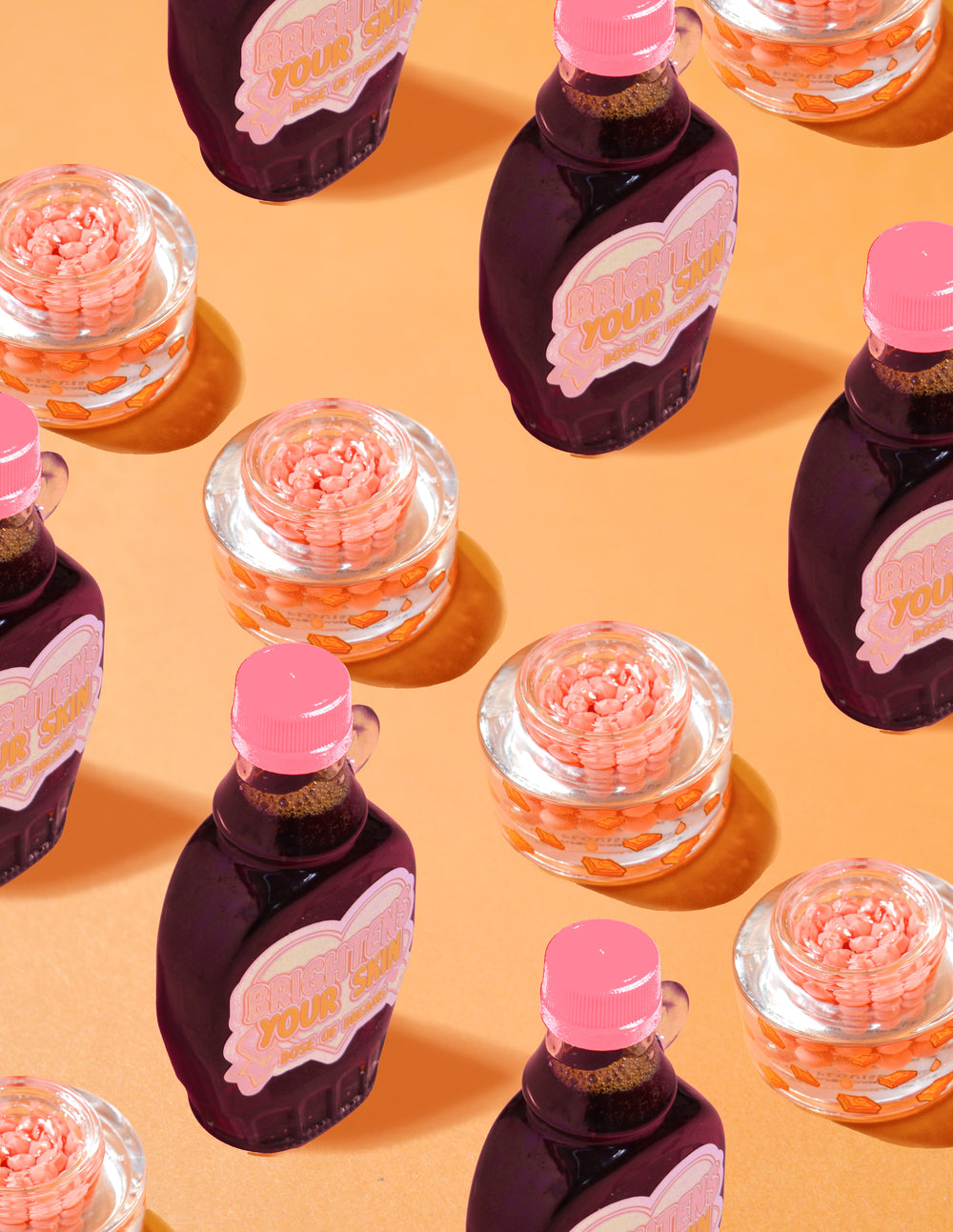 Recipiente transparente de P.Louise Dose of Dreams Vitamina C Capsulă Cremă cu capsule portocalii în interior, înconjurate de sticle de sirop violet și roz pe un fundal portocaliu