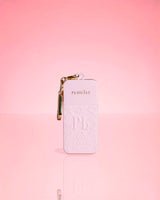 Pink bottle of P.Louise Hand Sanitiser Spray in signature scent with gold keychain on a pink background