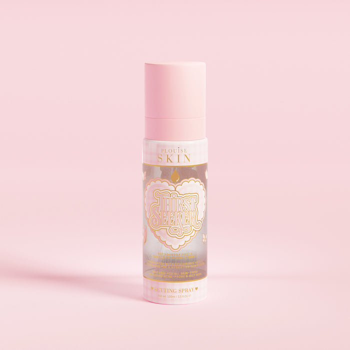 O sticlă de pulverizare roz inscripționată „P.Louise SKIN” cu o inimă și câteva elemente florale, care conține un spray hidratant.