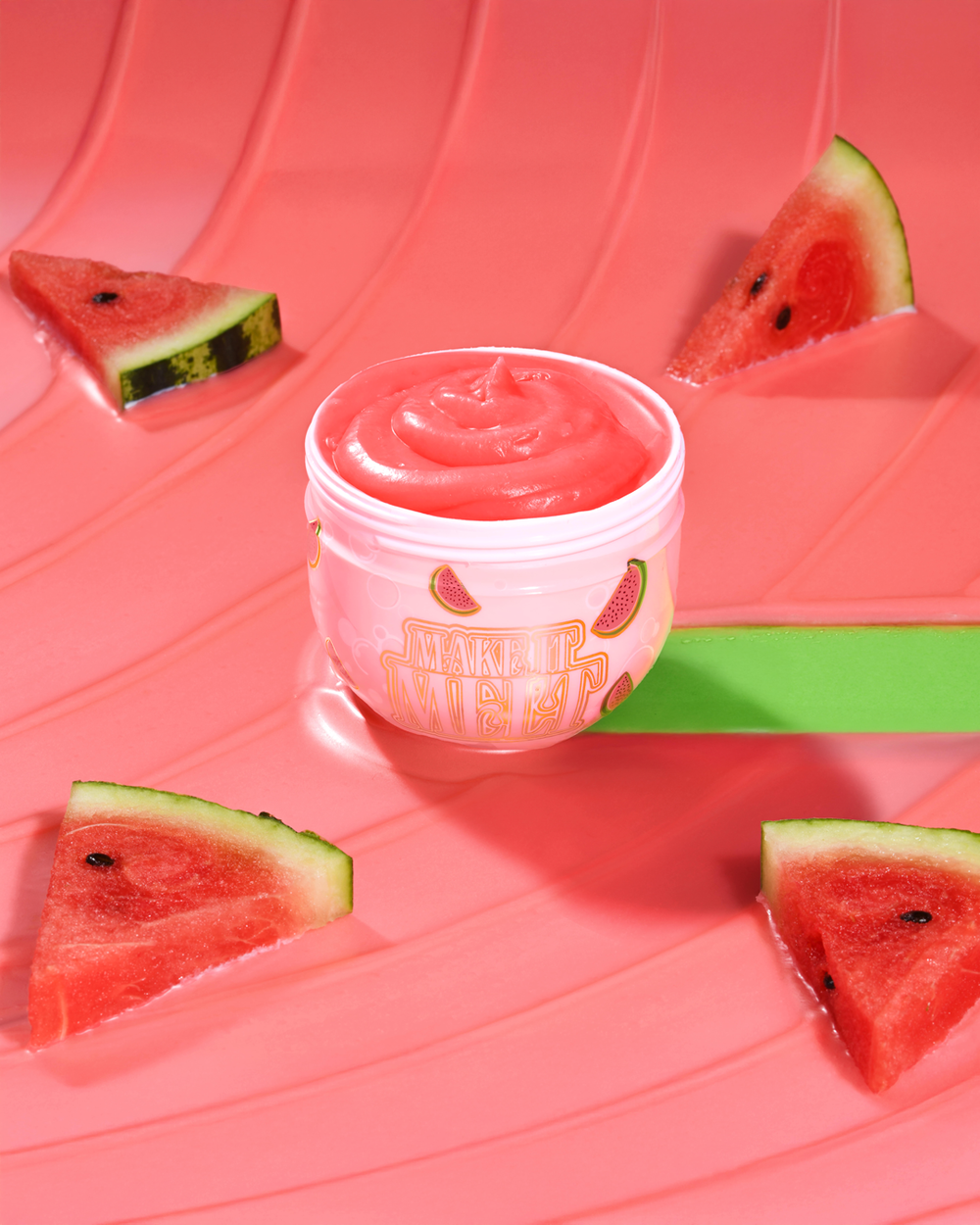 Deschide cuva de balsam de curățare al machiajului P. Louise Watermelon Make It Melt, înconjurat de pepeni verzi pe un fundal roșu