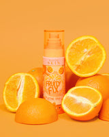 O sticlă portocalie de P. Louise Fruity Fix Vitamina C Setting Spray cu un fundal portocaliu înconjurat de felii proaspete de portocale.