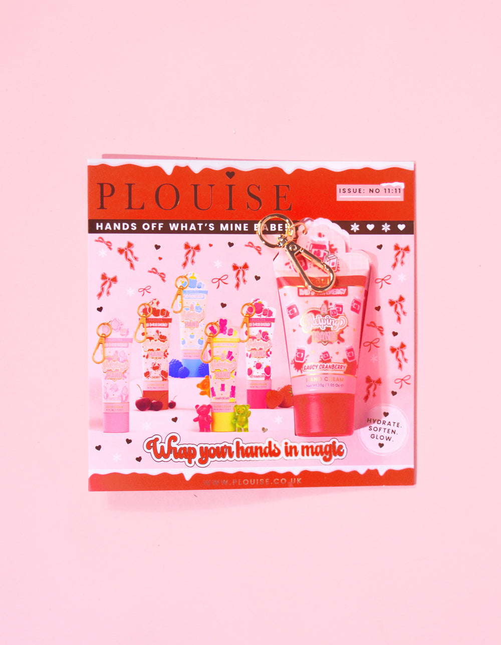 Revista de Crăciun P.Louise, cu un mini breloc cremă de mâini cu merișoare, atașat la reviste, cu un design festiv roșu și roz